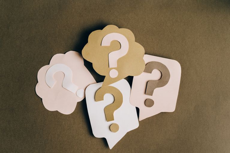 picture of a light brown background with different shaped speech bubbles cut out of different shades of light brown and cream card. Each bubble has a question mark in it, also cut out of different shades of brown and cream card