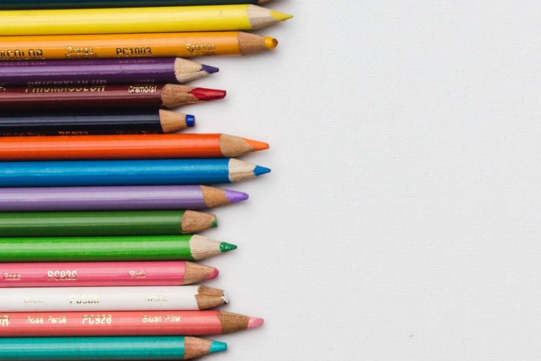 Close up picture of lots of brightly coloured pencils neatly lined up horizontally on the left of the picture. 